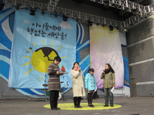후쿠시마 핵발전소 사고 피난민인 아베 사유리 씨와 딸 유리카 양이 10일 서울시청광장에서 열린 후쿠시마 대재앙 1주기 시민문화행사에 참석하여 무대 발언을 하고 있다.