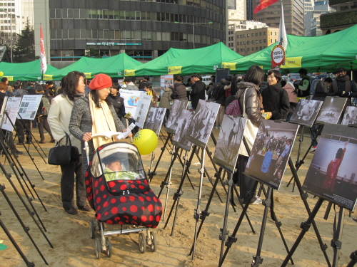 체르노빌과 후쿠시마 사람들의 모습을 담은 일본의 사진작가 모리즈미 다카시 씨의 사진전을 보고 있는 시민들.