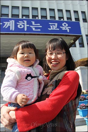  정당에 후원했다가 해임됐던 황영인 교사가 아이를 안고 15일 오후 경남도교육청 현관 앞을 찾았다. 황 교사는 법원으로부터 '해고 징계 무효 판결'을 받았는데, 교육청은 이에 불복해 항소했다. 황 교사는 해임 징계를 받았을 때가 출산 2개월 전이었다.