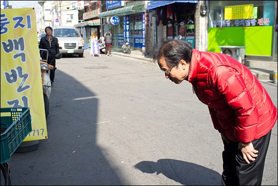 지난 3월 15일 홍준표 새누리당 후보가 장안동 일대를 돌며 점포 안의 유권자를 향해 허리 굽혀 인사하고 있다. 