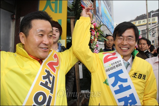 2012년 19대 총선 '사하갑'에 출마하는 민주통합당 최인호 예비후보가 그해 3월 17일 '사하을'에 출마하는 조경태 의원을 만나 손을 들어 보이고 있다.