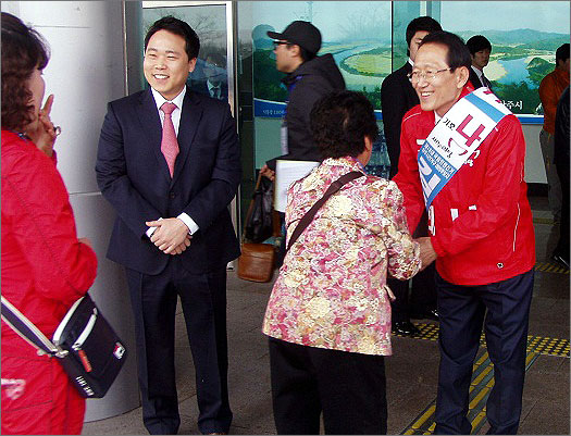 인사하는 김종태 후보. 김 후보가 투표인의 손을 잡고 지지를 호소하고 있다.