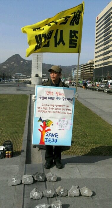 19일 오후, '잼다큐 강정'의 김일권 프로듀서가 '구럼비 바위 발파 중단'을 요구하는 일인시위에 참여하고 있다. 