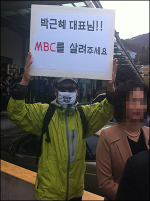 박근혜 새누리당 비상대책위원장이 경남 창원을 방문한 가운데 MBC 직원이 팻말을 들고 1인 시위를 하고 있다. 