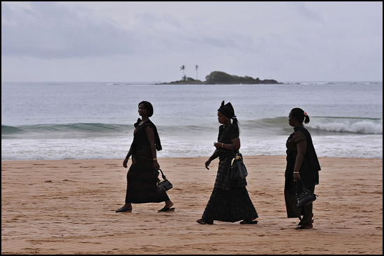 장례식에 참석하기 위해 해변을 지나가는 여인들