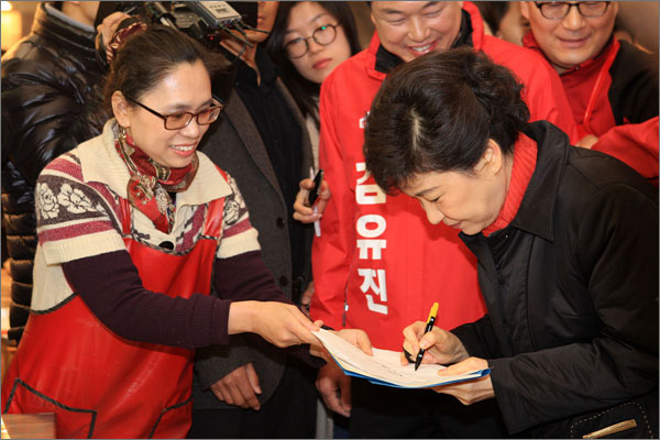 새누리당 박근혜 비상대책위원장이 22일 오전 경기도 군포시에 위치한 산본시장을 방문해 시장상인에게 사인을 해주고 있다.


