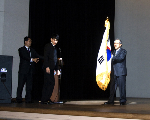 <한국광복군동지회> 김영관 회장이 무대 위에서 태극기를 받아 흔들어 보이고 있다. 