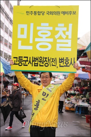 민주통합당 민홍철 국회의원선거 후보(김해갑)가 김해민속5일장을 찾아 홍보 피켓을 들어 보이고 있다.