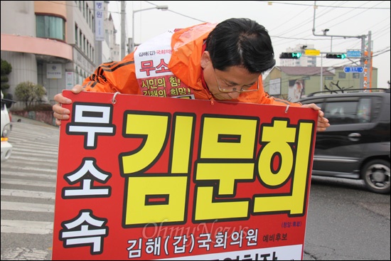 4.11총선 무소속 김문희 국회의원선거 후보(김해갑)가 거리에서 홍보피켓을 들고 인사를 하고 있다.