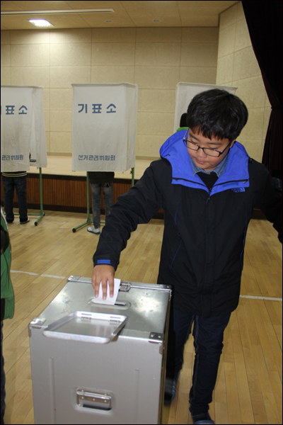 후보자들의 공약을 꼼꼼히 확인한 뒤 소신있게 투표했다는 꼬마 유권자가 기표한 뒤 투표함에 투표용지를 넣고 있다.