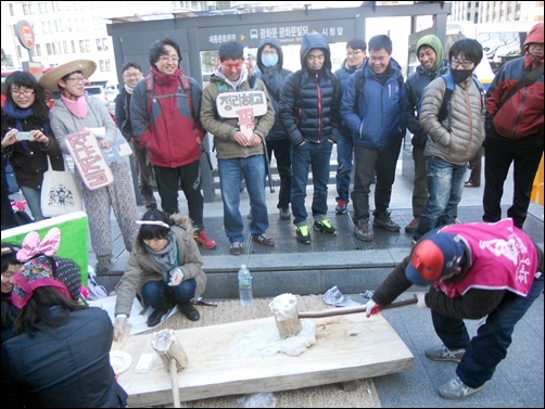 '희망광장'에 모인 사람들이 정리해고와 비정규직 철폐를 위한 떡메치기 행사에 참여하고 있다.