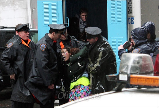 지난달 29일(현지시각) 미국 뉴욕 맨해튼 브라이언트 파크 인근에서 월스트리트 점령 시위를 벌이던 한 여성이 경찰에 체포된 뒤, 경찰 호송 차량 탑승을 거부하며 몸부림치고 있다.   
