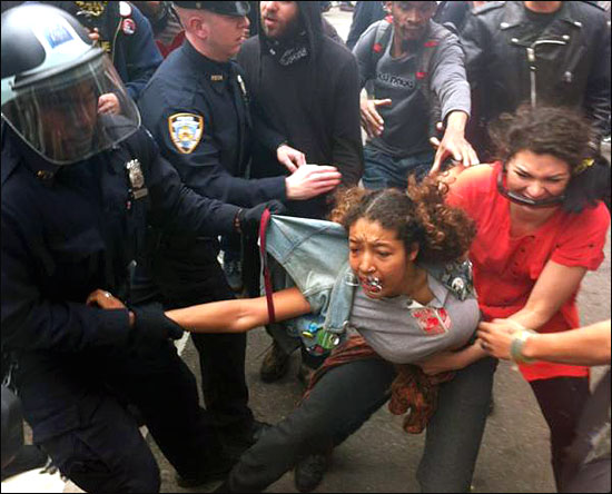 지난 24일(현지시간) 월스트리트 점령 시위대가 경찰의 과잉 진압에 항의하기 위해 거리 행진을 하는 도중, 16세의 한 소녀가 자신을 거칠게 낚아채는 경찰로부터 빠져나오기 위해 울부짖으며 몸부림치고 있다.