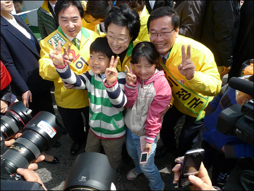 한명숙 민주통합당 대표가 안양 동안갑과 동안을 선거구 후보 지원 유세를 마치고 이동하던 도중 한 유권자와 함께 온 어린이들과 사진을 찍고 있다. 