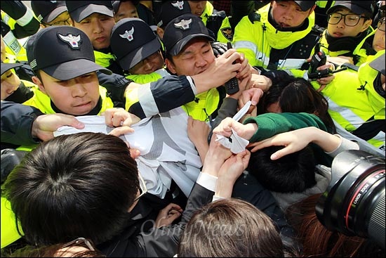  "사찰정권 독재정권 이명박정권 퇴진하라!"를 외쳐며 가두시위를 벌이는 대학생들을 경찰들이 인도 한구석으로 밀어 붙이고 있다.