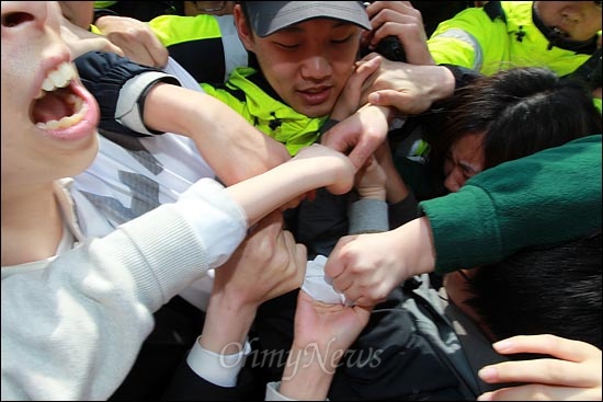  현수막을 사이에 두고 경찰과 대학생들이 뒤엉켜 아수라장이 벌어지고 있다.