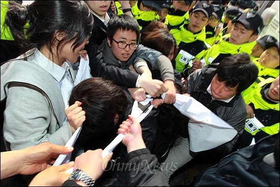  "사찰정권 퇴진하라!" 구호가 적힌 현수막을 뺏으려는 경찰에 맞서 대학생들이 현수막을 지키려 애를 쓰고 있다.