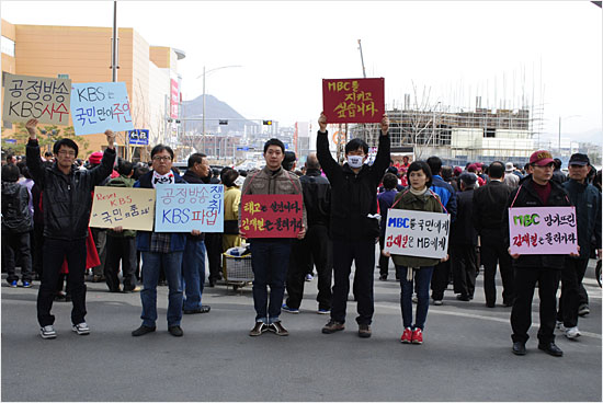 춘천풍물시장, 박근혜 선대위원장 지지유세 현장에서 피켓 시위를 벌이고 있는 춘천 KBS와 춘천 MBC 노조원들.