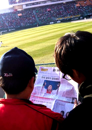 7일 문학구장에서 열린 SK-KIA전 경기장에 무료로 배포된 <조선일보>를 시민들이 읽고 있다.