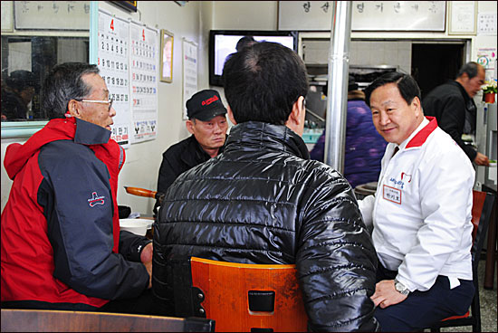  시장 안 한 주점에서 주민들과 이야기를 나누는 새누리당 한기호 후보.