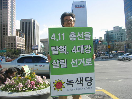 지난 4월 5일, 서울시 광화문 사거리에서 녹색당 김현 조직담당자가 '411선거를 탈핵, 4대강, 살림 선거로'라고 적힌 피켓을 들고 막바지 선거유세 활동을 하고 있다. 