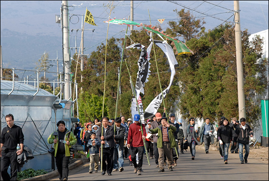 제주도 강정마을 주민들과 문화예술인들이 7일 '강정마을 4.3해원상생굿'을 벌인 후 거리행렬에 나서고 있다