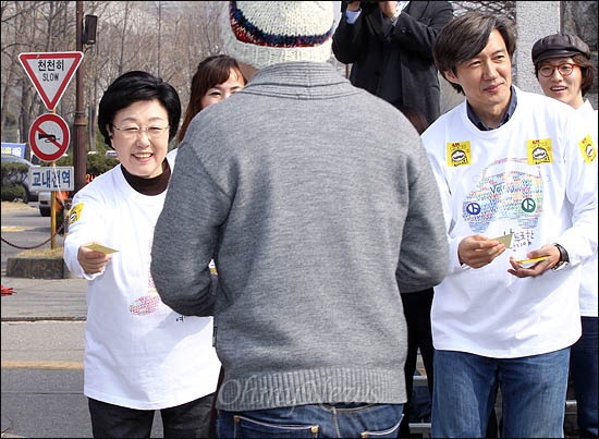  민주통합당 한명숙 대표와 조국 서울대 교수가 9일 오전 연세대 정문 앞에서 투표참여를 호소하며 스티커를 나눠주고 있다.