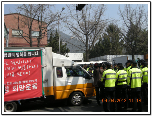  경찰이 진보신당 선거 유세차 진입을 막기 위해 차를 둘러싸고 있다.