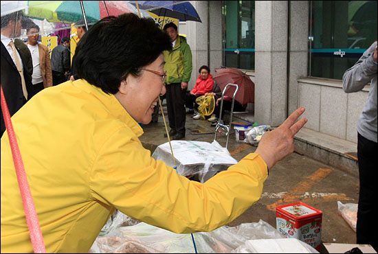 10일 오후 서울 용답동을 찾은 한명숙 민주통합당 대표가 시민들과 인사를 나누며 기호2번을 상징하는 손짓을 하고 있다.