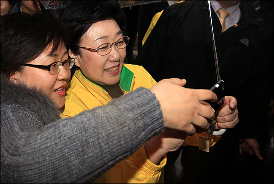 10일 오후 서울 용답동을 찾은 한명숙 민주통합당 대표가 시민의 요청으로 사진을 찍어 있다.