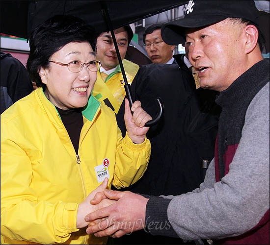 비가 내린 10일 오후 민주통합당 한명숙 대표가 서울 중구 신당동에서 우산을 받쳐들고 정호준 후보 지원유세를 펼치고 있다.