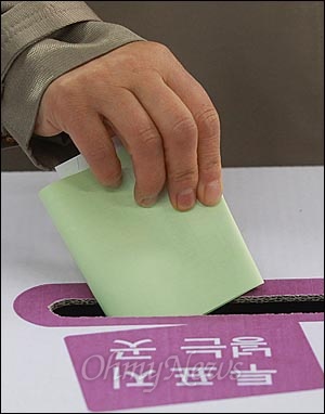 제19대 국회의원 선거날인 2012년 4월 11일 오전 서울 마포구 공덕동 주민센터에 마련된 제4투표소에서 유권자가 기표용지를 투표함에 넣고 있다.