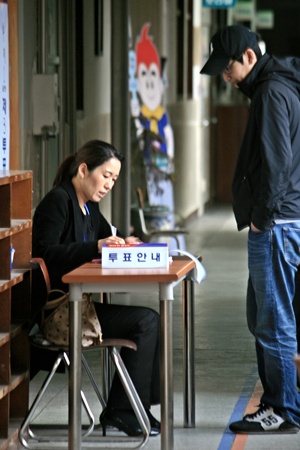 투표소 명부를 확인하고 있는 유권자