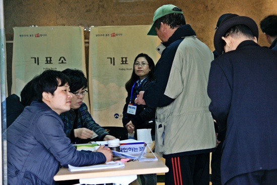 명부 확인 후 최종 신분 확인을 하러 들어가는 유권자들