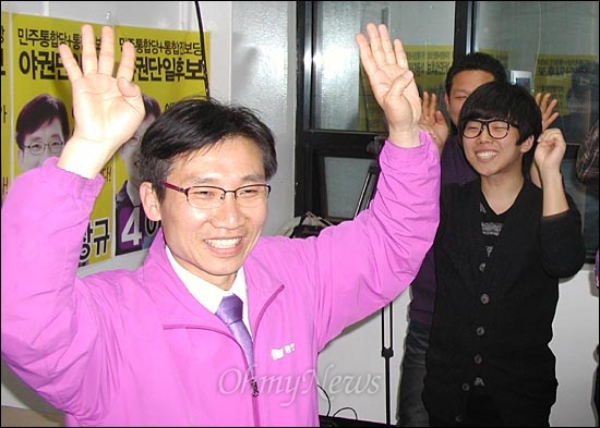 서울 관악을에 야권단일후보로 출마한 이상규 통합진보당 후보가 11일 오후 관악구 서원동 선거사무소에서 방송사 출구조사 발표 직후 승리를 예감한 듯 대학생 유세단 앞에서 두 팔을 번쩍 들고 있다.   