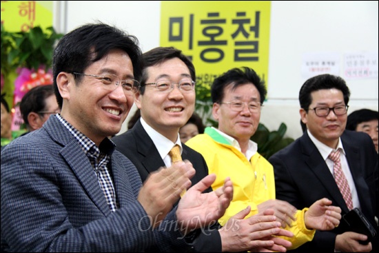 19대 국회의원 총선거에서 '김해갑'에 출마한 민주통합당 민홍철 후보가 11일 저녁 선거사무소에서 개표 상황 집계표를 바라보며 지지자들과 함께 박수를 치며 웃고 있다.