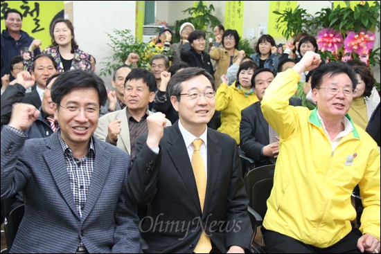 19대 국회의원 총선거에서 '김해갑'에 출마한 민주통합당 민홍철 후보(앞줄 가운데)가 11일 저녁 선거사무소에서 개표 상황을 전해 듣고 지지자들의 환호 속에 박수를 치며 기뻐하고 있다.
