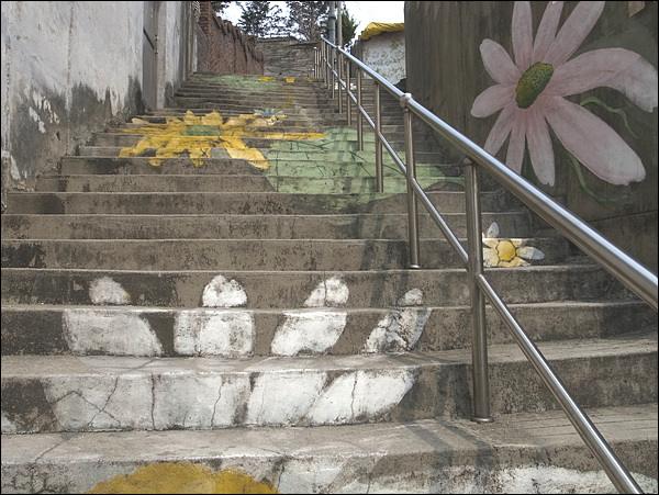 산동네를 오르는 계단과 벽에 그려진 그림. 꽃이 피어날 수 없는 곳에 꽃이 피길 바라는 마음으로 그림을 그렸을 것입니다. 