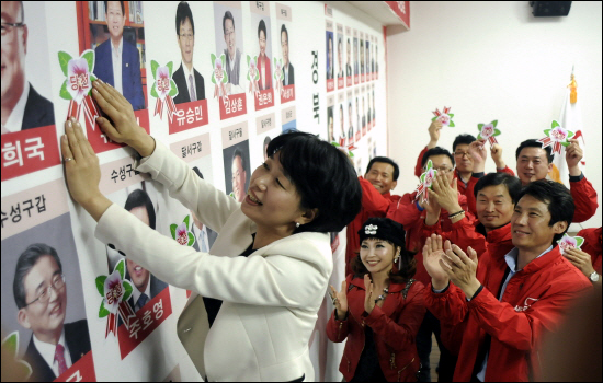 새누리당 대구시당에서 당선이 확정된 후보들의 사진에 꽃을 달고 있다