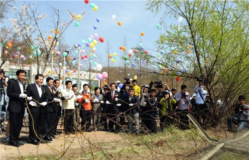 4월 19일 고양시에서 열린 철책제거 기념식에서 철책을 넘어뜨리는 퍼포먼스를 하고 있다.