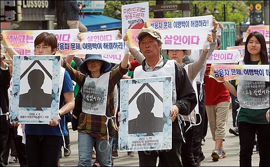 제122주년 세계 노동절인 1일 오후 서울 중구 서울역광장 앞 도로에서 노동자들과 학생들이 2009년 이후 쌍용자동차에서 정리해고로 목숨을 잃은 22명의 노동자와 가족들의 영정사진을 들고 "해고는 살인이다"를 외치며 행진을 하고 있다.