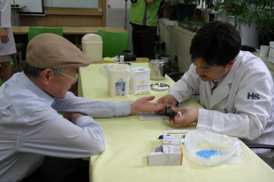 한신메디피아 의사가 노인 피 검사를 하고 있다.
