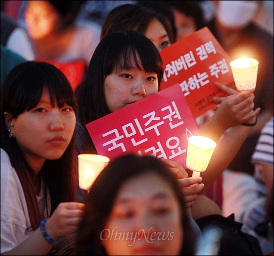 2일 오후 서울 청계광장에서 열린 '광우병 위험 미국산 쇠고기 수입중단 범국민촛불집회'에서 시민들이 촛불과 손피켓을 들고 참여하고 있다.