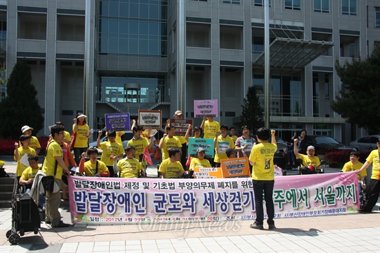  대전지역 장애인부모 및 장애인관련 단체 회원들이 '발달장애인법 제정'과 '부양의무제 기준 폐지'를 주장하며 광주에서 서울까지 500km 도보행진을 벌이고 있는 발달장애인 이균도씨와 그의 부친 이진섭씨과 함께 4일 오전 대전시청 앞에서 기자회견을 열고 있다.