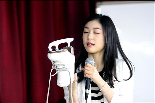  교생 김연아 선수가 한족 눈을 감고, 스케이트화를 응시하고 있다 