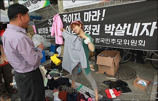 11일 오후 서울 중구 대한문 앞에서 열린 '쌍용자동차 희생자들을 돕기위한 후원 바자회'에서 한 자원봉사자가 시민들에게 기증된 물품을 보여주며 판매하고 있다.