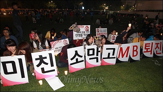 정부가 미국에 파견한 조사단의 조사 결과 미국산 수입 쇠고기는 안전하다고 결론을 내린 가운데, 12일 오후 서울시청광장에서 열린 '광우병위험 미국산 쇠고기 수입중단 국민촛불집회'에 참가한 대학생들이 미국산 쇠고기 수입 중단과 이명박 대통령의 퇴진 등을 촉구하며 피켓을 들어보이고 있다.