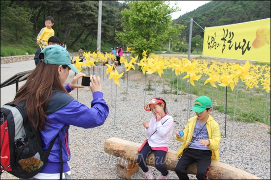  고 노무현 대통령 3주기를 앞두고 봉하마을에 참배객들이 몰려들고 있다. 사진은 묘역 옆에 있는 바람개비를 배경으로 가족들이 사진을 찍고 있는 모습.