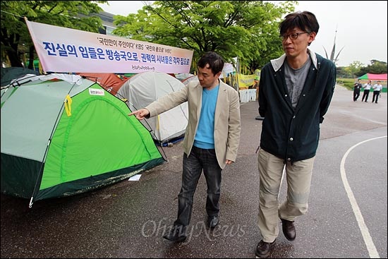 KBS노조 김현석 위원장과 MBC노조 정영하 위원장이 여의도공원에 설치된 '희망캠프'를 둘러보고 있다.