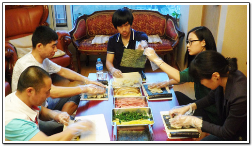 한국 가정 초대를 받은 이주노동자들이 김밥을 만들고 있다.